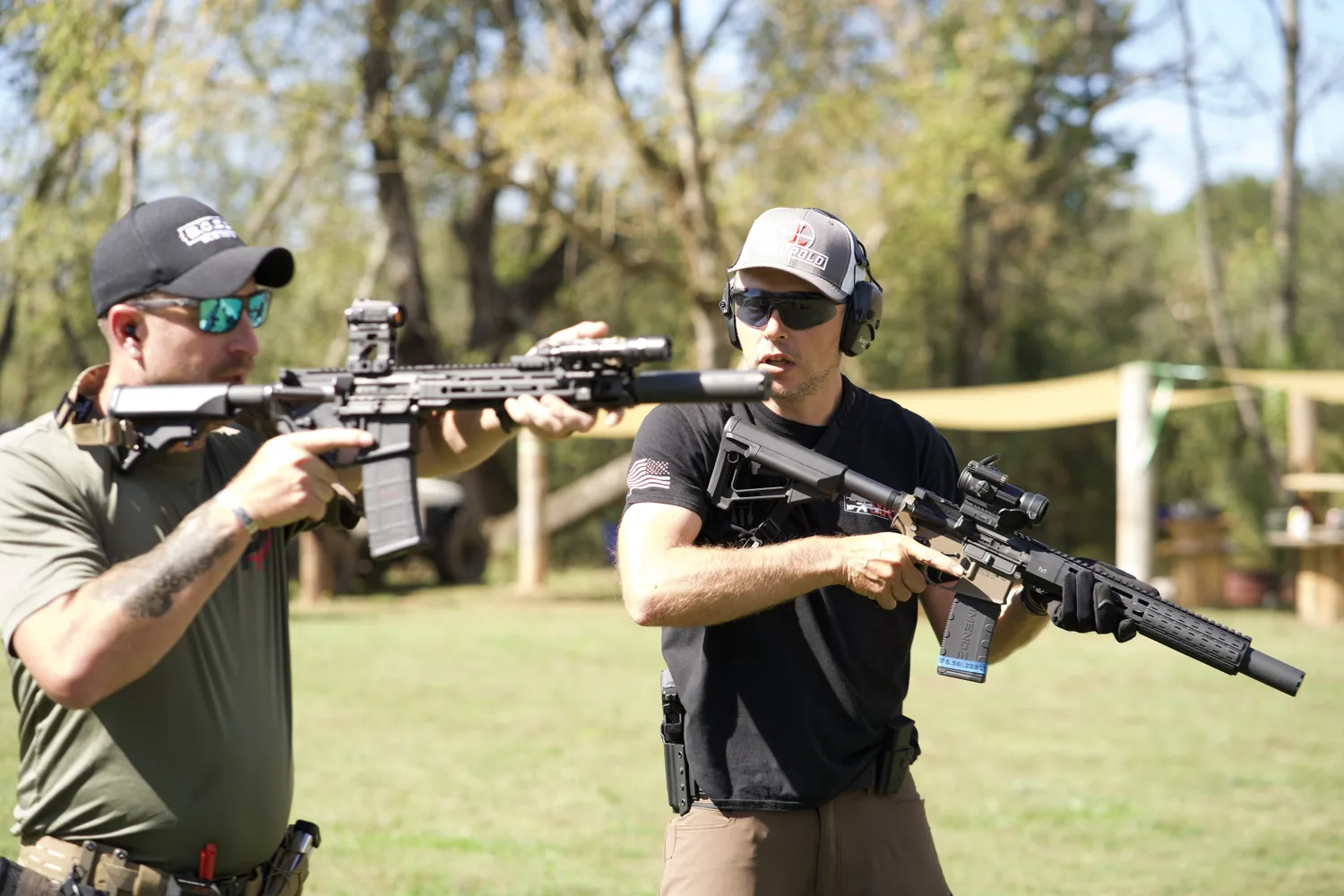 An instructor coaching a student one-on-one with carbines on the range